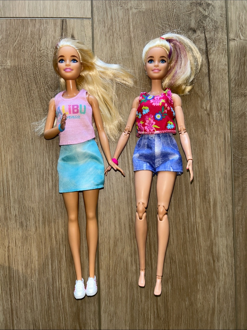 Two Barbies with travel accessories and two extra outfits